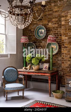 Plats en céramique Lebrillo avec des lampes sur une table antique et une chaise sous la fenêtre dans l'école victorienne de la fin du 19ème siècle, Battersea, Londres, Royaume-Uni Banque D'Images