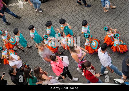 Enfants d'une école locale défilant en costumes colorés le jour portugais dans les rues pavées de São Vicente Banque D'Images