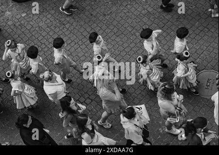 Les enfants monochromes d'une école locale défilent dans des costumes traditionnels uniques le jour portugais dans les rues pavées de São Vicente Banque D'Images