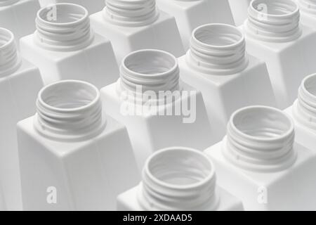 Grand groupe de bouteilles en plastique blanc vides prêtes à être remplies ou recyclées, ligne d'emballage ou de production, fond industriel abstrait Banque D'Images