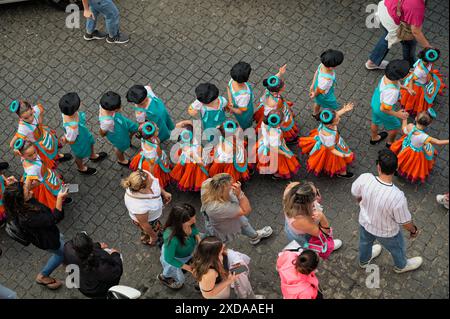 Enfants d'une école locale défilant en costumes colorés le jour portugais dans les rues pavées de São Vicente Banque D'Images