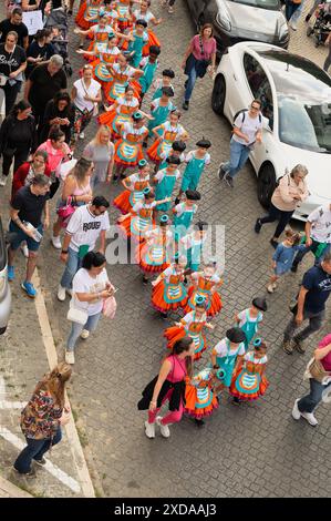 Enfants d'une école locale défilant dans une rue en costumes colorés avec des familles suivant la journée portugaise à São Vicente Banque D'Images