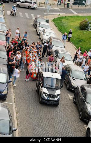 Enfants d'une école locale défilant dans une rue en costumes colorés avec des familles suivant la journée portugaise à São Vicente Banque D'Images