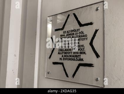 Budapest, Hongrie. 21 juin 2024 : plaque commémorative dans l'un des bâtiments désignés où 220 000 personnes ciblées ont été obligées de déménager après avoir été expulsées de leurs maisons. Aujourd'hui, nous commémorons le 80e anniversaire de ce réseau unique dans l'histoire de l'Holocauste en Europe. Du hongrois : 'du 21 juin 1944 jusqu'à la création du ghetto, ce bâtiment était l'endroit où les citoyens de Budapest définis comme juifs ont été forcés de vivre : une maison étoilée jaune. Érigé en 2014, à l'occasion du 70e anniversaire de l'Holocauste. Comme le ghetto, les maisons ont servi de phase préparatoire à la déportation. Crédit : Kevin Izorce/Alamy Live News Banque D'Images