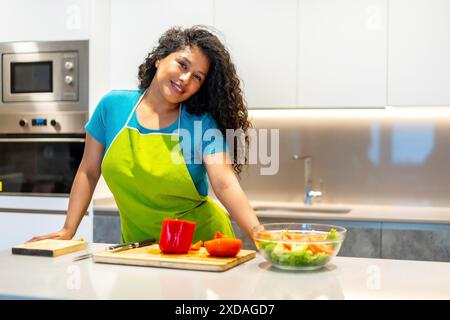 Portrait avec espace copie d'une jeune femme de beauté latine dans le tablier préparant des aliments sains dans la cuisine Banque D'Images