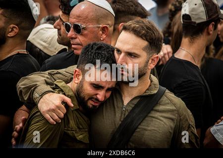 Les soldats israéliens se réconfortent mutuellement lors des funérailles du soldat Omer Smadga tombé, au cimetière militaire de Netanya vendredi 21 juin 2024. Smadga est morte jeudi au combat avec le Hamas dans la bande de Gaza. Son père, Oren, a parlé par-dessus sa tombe et a appelé les FDI à continuer à se battre aussi dur que possible, 'je dis aux soldats ici de garder la tête haute. Continuez aussi dur que possible. N'arrête pas jusqu'à ce qu'on gagne. C'est mon message à quiconque au combat. AM Israel Hai, Ó. Oren Smadga est le médaillé olympique israélien en judo des Jeux Olympiques de Barcelone 1992 et l'entraîneur actuel de l'israélien Banque D'Images