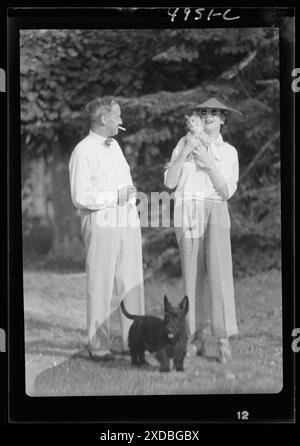 Leonard, Mr. et Mrs., avec chat et chien, debout à l'extérieur. Collection de photographies Genthe. Banque D'Images