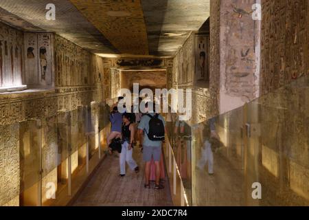 Les visiteurs admirent la décoration dans le couloir menant à la chambre funéraire de Ramsès III dans la Vallée des Rois, Louxor, Egypte. Banque D'Images