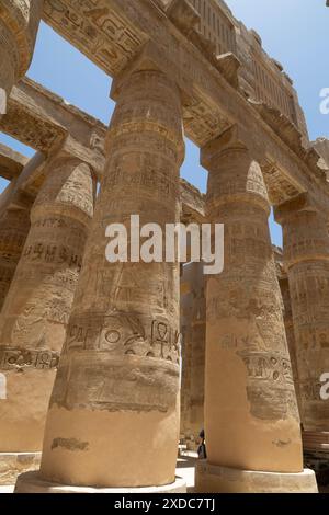 Grandes colonnes papyriformes à bourgeons fermés dans la salle hypostyle du complexe Amun-Ra à Karnak, Égypte avec des architraves peintes et des fenêtres à clerestory. Banque D'Images