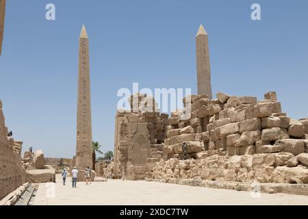 Deux obélisques, l'un à moitié caché érigé par Hatshepsout dans la salle Wadjyt et l'autre par Toutmosis Ier devant le quatrième Pylône à Karnak, en Égypte. Banque D'Images