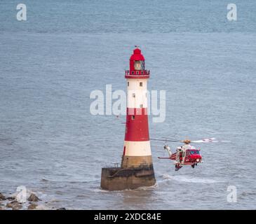 Sussex, Royaume-Uni. 21 juin 2024. HM Coastguard abaisse un brancard pendant une opération de recherche et de sauvetage pour une personne disparue à côté du phare de Beachy Head avec le canot de sauvetage côtier RNLI à proximité. Beachy Head, Seven Sisters National Park, East Sussex, Royaume-Uni crédit : Reppans/Alamy Live News Banque D'Images