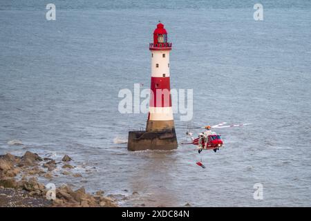 Sussex, Royaume-Uni. 21 juin 2024. HM Coastguard abaisse un brancard pendant une opération de recherche et de sauvetage pour une personne disparue à côté du phare de Beachy Head avec le canot de sauvetage côtier RNLI à proximité. Beachy Head, Seven Sisters National Park, East Sussex, Royaume-Uni crédit : Reppans/Alamy Live News Banque D'Images