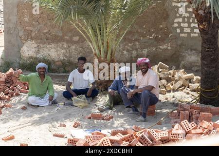 Quatre villageois égyptiens du village de Bisaw sur une île du Nil à environ 90 km au nord d'Assouan prennent une pause-travail sur une plage. Banque D'Images