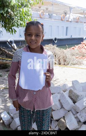 Une jeune égyptienne en robe moderne de Bisaw, sur une île du Nil à environ 90 km au nord d'Assouan, montre fièrement son dessin. Banque D'Images