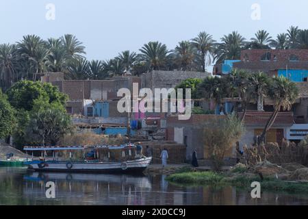 Quatre hommes égyptiens habillés traditionnellement sont déjà au travail derrière un ferry sur le Nil à 6h30 a.m.in Bisaw, un village coloré en briques de boue au bord de la rivière. Banque D'Images