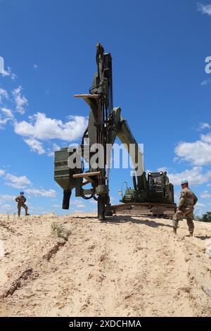 Des soldats du 106th Engineer Detachment (Quarry) travaillent à un projet de forage de trous pour une démolition de carrière le 7 juin 2024, à Fort McCoy, Wisconsin. Les soldats du 106th subissaient une explosion le 8-9 juin à Fort McCoy quand ils ont coordonné une paire de démolitions de carrières à l’installation pour aider à démonter une colline de grès qui fait partie d’un projet de troupes en cours au poste. Le 106th fait partie de la Garde nationale du Wisconsin et est une unité unique - l'une des six seulement dans l'armée - qui effectue des opérations de carrière. (Photo de l'armée américaine par Scott T. Sturkol, Bureau des affaires publiques, Fort McCoy, Wisconsin.) Banque D'Images