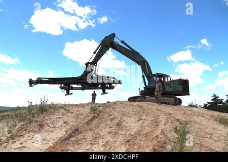 Des soldats du 106th Engineer Detachment (Quarry) travaillent à un projet de forage de trous pour une démolition de carrière le 7 juin 2024, à Fort McCoy, Wisconsin. Les soldats du 106th subissaient une explosion le 8-9 juin à Fort McCoy quand ils ont coordonné une paire de démolitions de carrières à l’installation pour aider à démonter une colline de grès qui fait partie d’un projet de troupes en cours au poste. Le 106th fait partie de la Garde nationale du Wisconsin et est une unité unique - l'une des six seulement dans l'armée - qui effectue des opérations de carrière. (Photo de l'armée américaine par Scott T. Sturkol, Bureau des affaires publiques, Fort McCoy, Wisconsin.) Banque D'Images