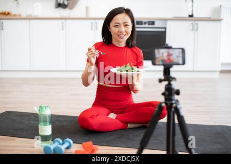 Femme enregistrant un vlog de saine alimentation dans la cuisine Banque D'Images