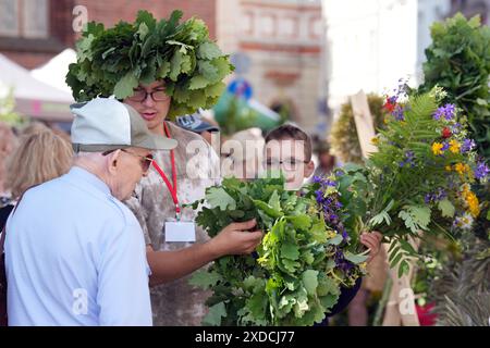 Riga, Lettonie. 21 juin 2024. Un homme vend une couronne de feuilles de chêne au marché Ligo Festival de Riga, Lettonie, le 21 juin 2024. Le festival annuel de la mi-été Ligo Market a ouvert ici vendredi, au cours duquel les agriculteurs et les artisans de toute la Lettonie vendent des spécialités telles que le pain rural, le fromage, le thé traditionnel, le miel, les gâteaux faits à la main et les chapelets. Credit : Edijs Palens/Xinhua/Alamy Live News Banque D'Images