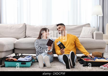 Couple avec passeports et billets près des valises à l'étage à l'intérieur Banque D'Images