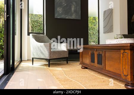 Lumière du soleil qui pénètre dans le salon moderne avec fauteuil et table basse en bois, espace photocopie Banque D'Images