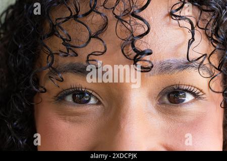 Portrait en gros plan de femme aux cheveux bouclés et aux yeux expressifs Banque D'Images