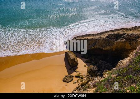 Belle vue d'en haut de l'océan vacillant. Plage de sable avec sable jaune et un rocher formant une grotte. Prainha das Pocas Banque D'Images