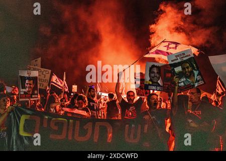 Israël. 20 juin 2024. Les manifestants se tiennent aux côtés des membres de la famille des otages israéliens Matan Zangauker et Dror ou alors qu'ils agitent le drapeau israélien et tiennent leurs photos et une pancarte qui dit : « il y a des otages, il n'y a pas de maison ». Des milliers de manifestants anti-Netanyahu ont manifesté dans les dunes à côté de la résidence du premier ministre Benjamin Netanyahu pour exiger un accord d'otages et des élections générales. Césarée, Israël. 20 juin 2024. (Matan Golan/Sipa USA). Crédit : Sipa USA/Alamy Live News Banque D'Images