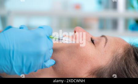 Femme ayant une injection de remplisseur de joue avec de l'acide hyaluronique. Banque D'Images