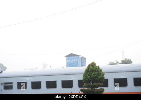 Un bâtiment d'usine vu de derrière un train en Indonésie dans la matinée Banque D'Images