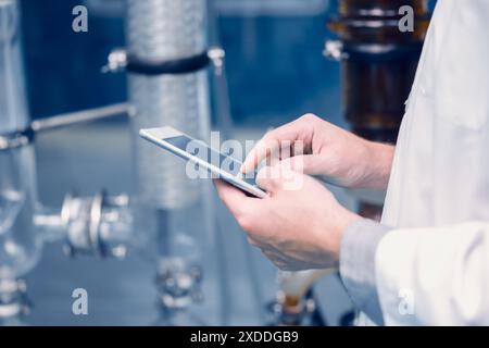 Scientist Medical Factory personnel travaillant dans Science Lab. Employé de technicien d'usine de médecine vérifier la qualité des produits de soins dans la salle de stérilisation avec tablette Banque D'Images