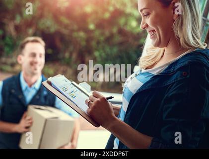 Femme, porte d'entrée et signature avec homme de messagerie pour boîte avec presse-papiers, facture ou reçu avec sourire. Personnes, livraison et colis avec liste de contrôle Banque D'Images