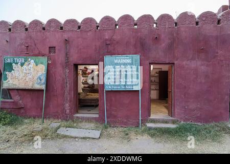 Panneau d'avertissement de comportement Safari et panneau de peinture « Save Tiger » délavé à l'entrée du parc national de Ranthambore, Rajasthan, dans le nord de l'Inde Banque D'Images