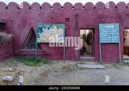 Panneau d'avertissement de comportement Safari et panneau de peinture « Save Tiger » délavé à l'entrée du parc national de Ranthambore, Rajasthan, dans le nord de l'Inde Banque D'Images