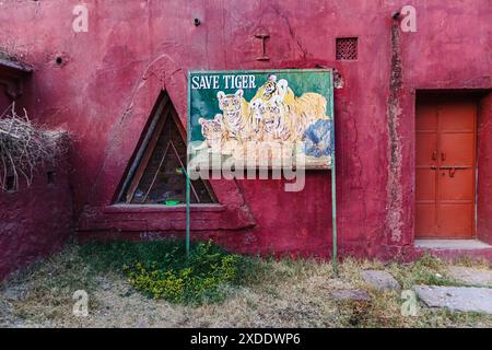 Peeling peinture sur un panneau « Save Tiger » délavé avec des photos de tigres à l'entrée de la porte Jogimahal du parc national de Ranthambore, Rajasthan, Inde Banque D'Images