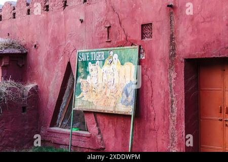 Peeling peinture sur un panneau « Save Tiger » délavé avec des photos de tigres à l'entrée de la porte Jogimahal du parc national de Ranthambore, Rajasthan, Inde Banque D'Images