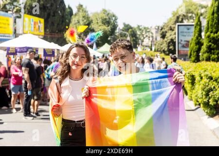 Haïfa, Israël 21 juin 2024, fierté. Les jeunes femmes tiennent un drapeau arc-en-ciel dans la foule. Banque D'Images