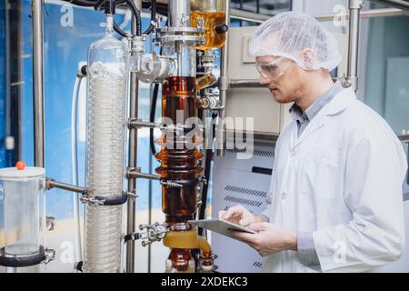 Scientifique travaillant avec des équipements dans Science Lab. Personnel d'usine médicale extraction d'huile de cannabis CBD. Usine de distillation de film mince d'huile de chanvre processus. Banque D'Images