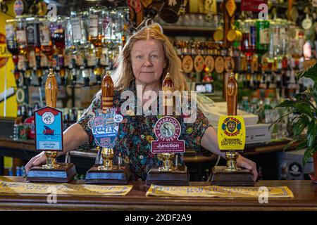 Les maçons arment avec la propriétaire et propriétaire : Rae Williams behinde la pompe à bière Banque D'Images