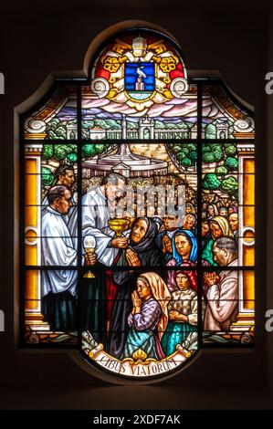 Un prêtre distribuant la communion aux fidèles. Un vitrail dans la basilique notre-Dame du Rosaire à Fatima, Portugal. Banque D'Images