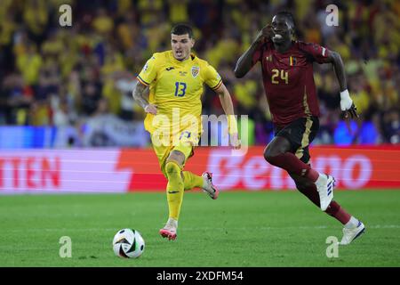 Cologne, Allemagne. 22 juin 2024. Le belge Amadou Onana et le roumain Valentin Mihaila (R) se battent pour le ballon lors du match de football UEFA Euro 2024 Groupe E entre la Belgique et la Roumanie au stade de Cologne. Crédit : Rolf Vennenbernd/dpa/Alamy Live News Banque D'Images