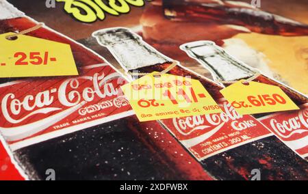 Viersen, Allemagne - 9 mai. 2024 : détail de la publicité pour Coca Cola asiatique singulier avec des étiquettes de prix en roupie sur les bouteilles du Sri Lanka vers les années 1990 (Focus on c Banque D'Images