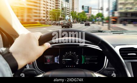 Homme conduisant la voiture avec une main sur le volant, gros plan. Conception de bannière Banque D'Images