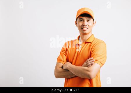 Portrait professionnel livraison attrayante homme asiatique heureux debout il sourit portant un t-shirt orange Banque D'Images