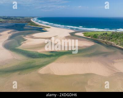 Vue aérienne d'une rivière côtière serpentant son chemin à travers des barres de sable et en mer sur une plage de sable à Wallaga Lkae en Nouvelle-Galles du Sud, Australie Banque D'Images