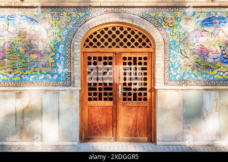 Téhéran, Iran - 19 octobre 2018 : vue imprenable sur la porte en bois sculptée menant à l'intérieur du palais du Golestan. Décoration murale en tuiles colorées. Banque D'Images