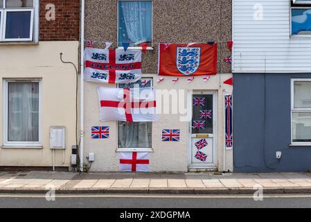 Façade d'une maison décorée patriotiquement pour montrer le soutien à l'Angleterre lors d'un tournoi de football avec une variété de drapeaux. Banque D'Images