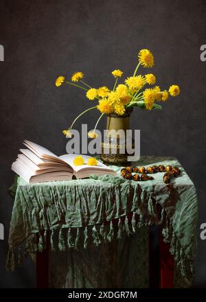 Pissenlits jaunes dans un vase et un livre ouvert sur la table Banque D'Images