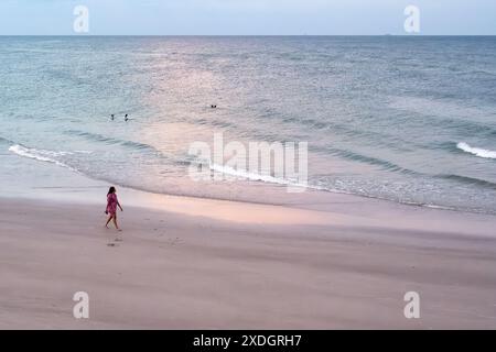 Femme marchant le long du rivage au crépuscule sur Jacksonville Beach dans le nord-est de la Floride. (ÉTATS-UNIS) Banque D'Images