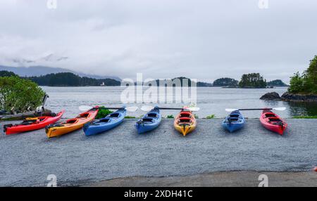 Kayaks sur la rive de Sitka Sound, phare de Rockwell au loin. Sitka. Alaska. Banque D'Images